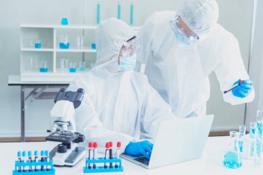 İki Asyalı bilim adamı kimya bilimi tüpü deney tüpü antikor örneğini kovid-19 virüsüne karşı laboratuvar geliştirmek için depoluyorlar. Kimya Laboratuarı 'nda bilim adamı danışmanı, analizi