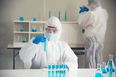 İki Asyalı bilim adamı kimya bilimi tüpü deney tüpü antikor örneğini kovid-19 virüsüne karşı laboratuvar geliştirmek için depoluyorlar. Kimya Laboratuarı 'nda bilim adamı danışmanı, analizi