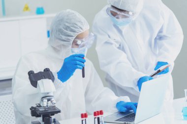 İki Asyalı bilim adamı kimya bilimi tüpü deney tüpü antikor örneğini kovid-19 virüsüne karşı laboratuvar geliştirmek için depoluyorlar. Kimya Laboratuarı 'nda bilim adamı danışmanı, analizi