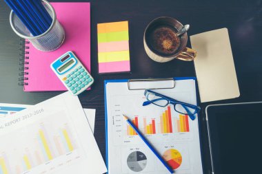 Ofis dizüstü bilgisayarının finansal döküman şeması ve kahve fincanı ile ahşap masanın üzerindeki grafiği. Düz dizüstü bilgisayar ofis masasında duruyordu. İş sahasında iş grafiği modellemesi yok