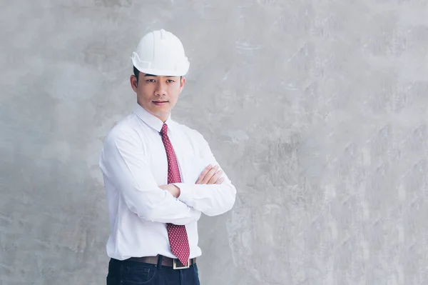 Construction engineer in Safety Suit Trust Team Holding White Yellow Safety hard hat Security Equipment on Construction Site. Hardhat Protect Head for Civil Construction Engineer. Engineering Concept