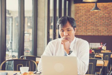 Kahve dükkanında iş yapmayı düşünen yakışıklı bir iş adamı. Stres işadamı konferans odasında dizüstü bilgisayardan posta okuyor. İş Konsepti.