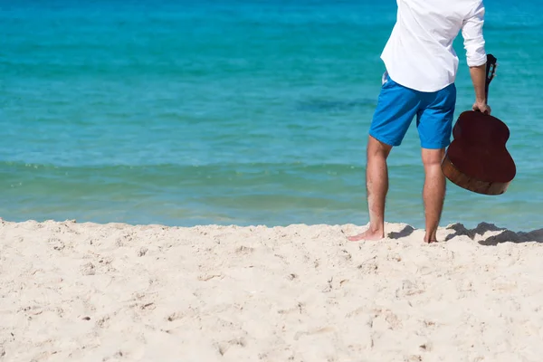 Young man travel outdoor on tropical beach with blue sky and white cloud using DSLR professional camera take a photo on vacation time with love nature. Outdoor travel lifestyle concept.