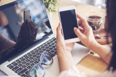 İşe yeni başlayan genç bir iş kadını akıllı telefondan iyi haberlerin tadını çıkarıyor. Asyalı iş adamları ev ofisinde mutlulukla çalışıyorlar.