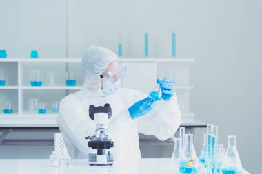 Bilim adamı covid-19 virüs kimya araştırması biyoteknoloji antikor örneği laboratuvarı virüse karşı aşı üretiyor. Bilim adamı mikroskoba bakıyor, bilim test tüpü kimya laboratuvarını analiz ediyor.