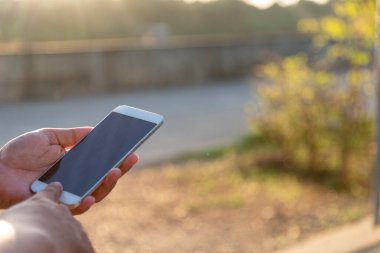 Elinde cep telefonu olan bir adam internette internet teknolojisiyle sörf yapıyor. Akıllı telefondan mesaj göndererek eli kapat boş boş ekran akıllı telefonu odakla. Cep telefonu yaşam tarzı