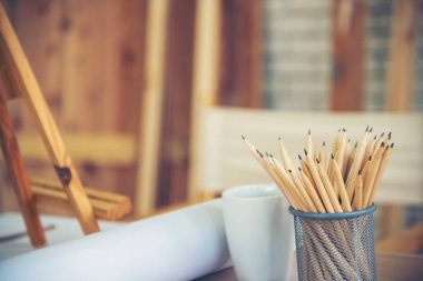 Pankart saksısı, kalem keskinliği, ofis dekorasyonu, ahşap masa. Yeşil dekore edilmiş ofis masası. Ahşap ofis masasındaki yeşil saksı vazosu kalem kutusu ofisini fotokopi alanı ile dekore et.