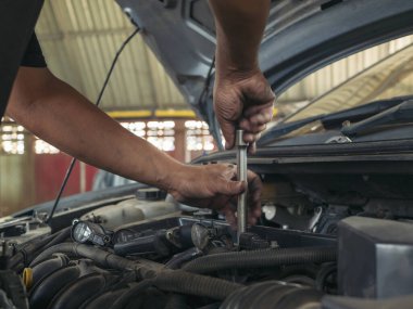 Otomobil makinelerinin mekanik servisini tamir eden elleri kapatın. Tamirci araba tamirhanesini tamir ederken ellerini kaldırdı. Araç kaputu otomobili kontrol ediyor. Araç bakım mühendisi.