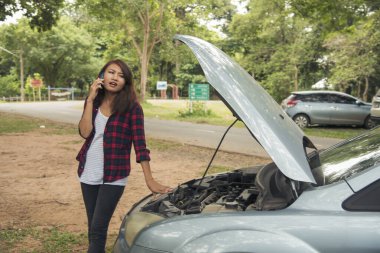 Asyalı kadınlar araba arızası için sigorta acentesini kullanıyorlar. Kadın tamirci teknisyenini arıyor. Tamir onarım desteği. Taşıma aracı kazası acil durum sorunu