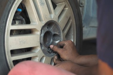 Tamirci, otomotiv merkezi servisleri için servis garajında araba lastiklerini kontrol ediyor. Teknisyen atölyesinde lastik kontrolü motorlu taşıtlar servis mekanik elleri