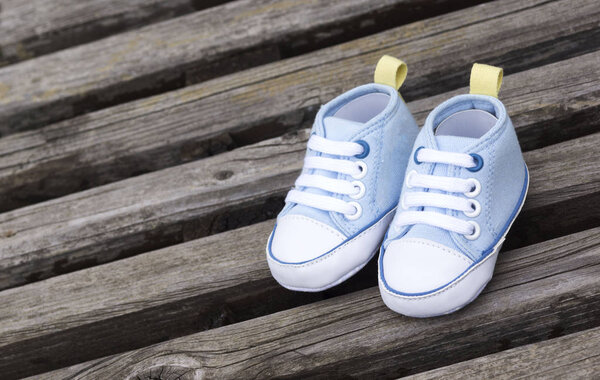 Голубая детская обувь на деревянной поверхности

