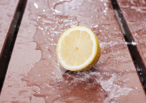 Rebanada Limón Una Mesa Madera Con Agua Que Fluye Sobre — Foto de Stock