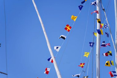 Mavi gökyüzü arkaplanlı gemi direği çizgilerinde bayraklar