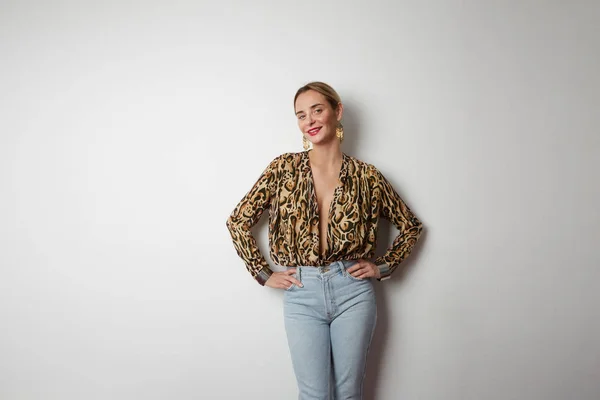 Молода позитивна жінка з одягненим леопардовим милосердям і джинсами — стокове фото