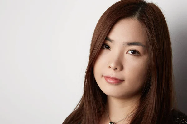 Ritratto di bella donna asiatica con i capelli lunghi in posa su sfondo bianco. Scherzi? . — Foto Stock