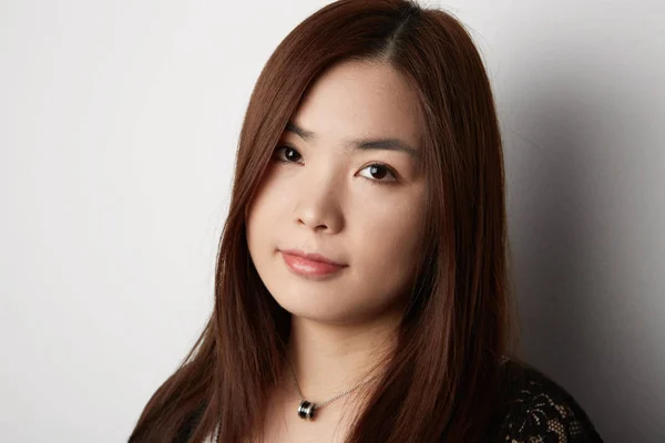 Bella donna coreana con i capelli lunghi in posa su sfondo bianco. Scherzi? . — Foto Stock