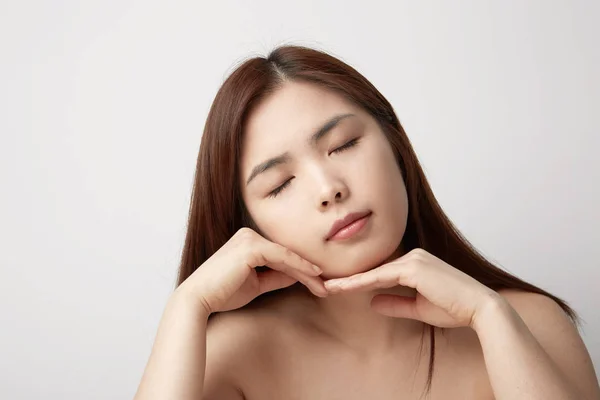 Retrato de jovem bela mulher sexy asiática relaxar sobre a parede branca. Sorriso menina asiática feliz olhando . — Fotografia de Stock