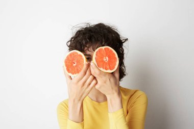 Oldukça çekici turuncu iki adet olan neşeli çekici neşeli doğal saf kız, beyaz arka plan üzerinde izole. Yakın çekim.