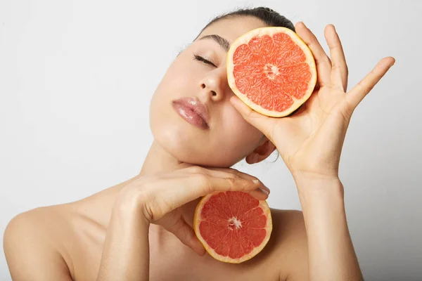 Vrij charmante vreugdevolle aantrekkelijke vrolijke natuurlijke zuivere dame met gesloten ogen hebben twee stukken van Oranje, geïsoleerd op een witte achtergrond. Close-up. — Stockfoto