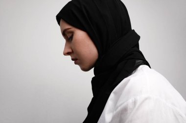 Beyaz arka planda tecrit edilmiş tesettürlü genç müslüman kadının yan görüntüsü. Kadın dini İslam yaşam tarzı konsepti. 