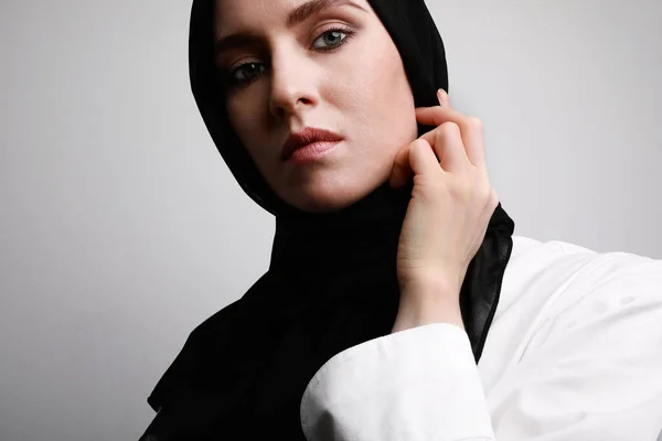 Portrait latéral en gros plan de la belle femme musulmane en hijab portant des vêtements blancs. Isolé au-dessus du mur blanc . — Photo