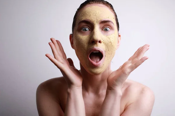 Mujer sorprendente con mascarilla facial hidratante con linda sonrisa aislada sobre fondo gris. Belleza y cuidado de la piel . —  Fotos de Stock