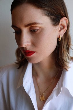 Kırmızı dudaklı çekici genç bir kadın. Sarışın. Göz makyajlı güzel bir kadın. Dikey.