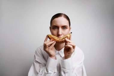 Muzu dudakmış gibi gösteren güzel bir kızın portresi. Stüdyo çekimi.