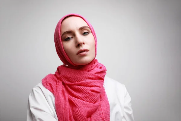Retrato frontal de jovem muçulmana em hijab rosa posando contra a parede. Espaço para texto . — Fotografia de Stock