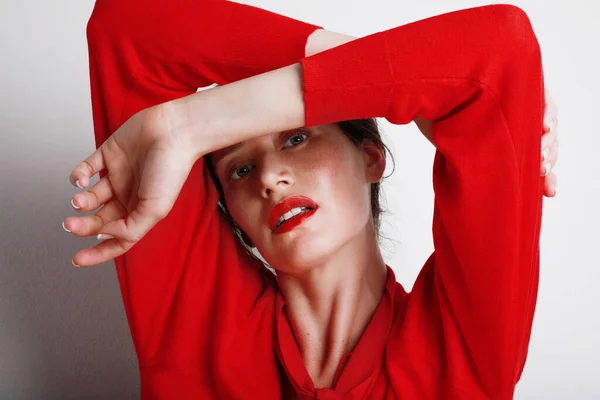 Kopfschuss einer schönen jungen kaukasischen Frau mit rotem Oberteil und rotem Lippenstift. Posieren über weißem Hintergrund. — Stockfoto