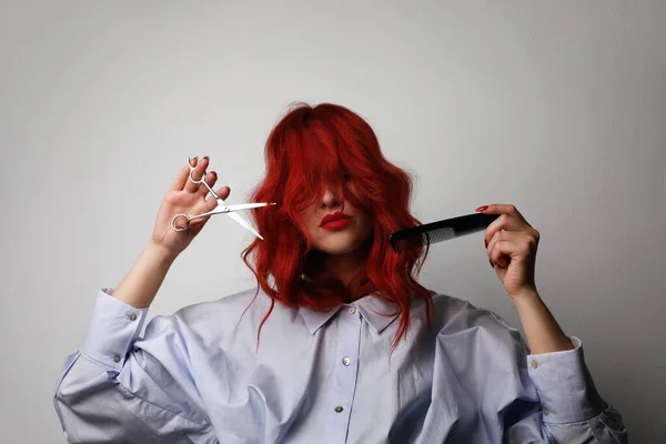Wanita penata rambut dengan gunting berpura-pura memotong rambut merahnya. Ruang untuk teks. — Stok Foto