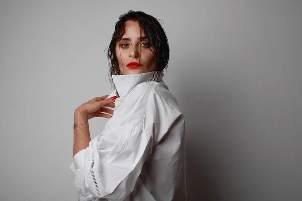 Mujer segura con camisa blanca posando sobre fondo gris . —  Fotos de Stock