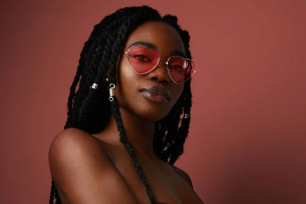 Retrato de una joven afro mujer de piel oscura sintiéndose feliz y despreocupada. Posando sobre fondo colorido. — Foto de Stock