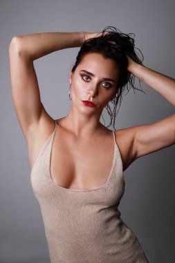 Moda elbiseli, çekici, şehvetli bir kadının yakın çekim stüdyo portresi. Sağlıklı dalgalı uzun saçlar. Beyaz arkaplan.