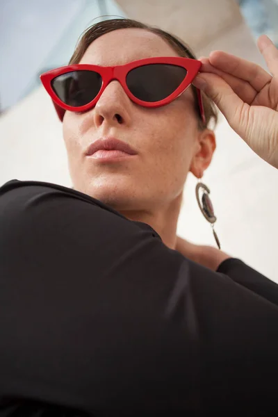 빨간색 선글라스를 착용하고 야외에서 행복하고 명랑 한 여성의 수직 사진. — 스톡 사진