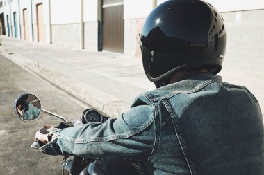 Motosiklet süren motosikletli adamın yakın çekimi, arka görüş. Metin için boşluk.