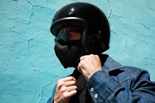 검은 제트 헬멧을 쓰고 파란 벽을 두른 자전거타는 사람의 근접 사진. — 스톡 사진