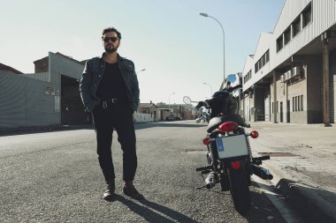 Mutlu sakallı motorcu bilinmeyen büyük bir motorsikletle yolda kalıyor. Açık hava..