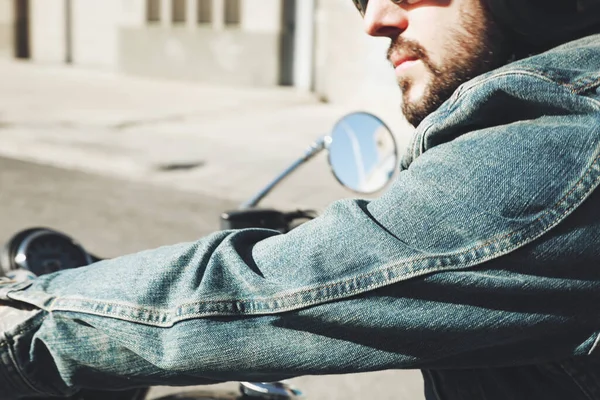 Nahaufnahme eines bärtigen Radfahrers, der mit einem unbekannten großen Chopper auf der Straße bleibt. — Stockfoto