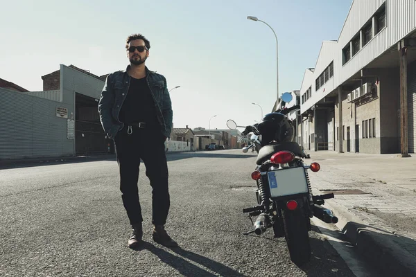 Mutlu sakallı motorcu bilinmeyen büyük bir motorsikletle yolda kalıyor. Açık hava..