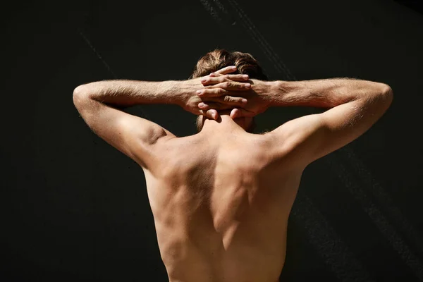 Perfect passende man van achteren met gekruiste armen. Donkere achtergrond. — Stockfoto