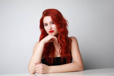 İzole edilmiş beyaz arka plan pozu veren sevimli, genç bir kadının yakın plan fotoğrafı. Metin için boşluk.