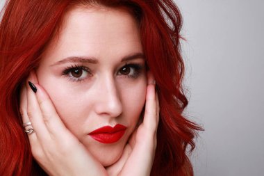 Beyaz arka planda poz veren güzel kızıl saçlı şehvetli ve çekici bir kadının yakın plan portresi. Metin için boşluk.