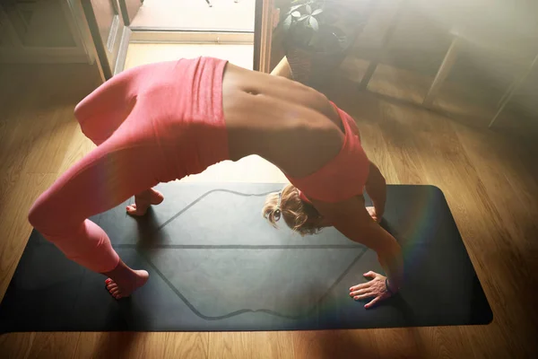 Wanita muda melakukan latihan yoga pagi di rumah, menggunakan laptop cor yoga online. — Stok Foto