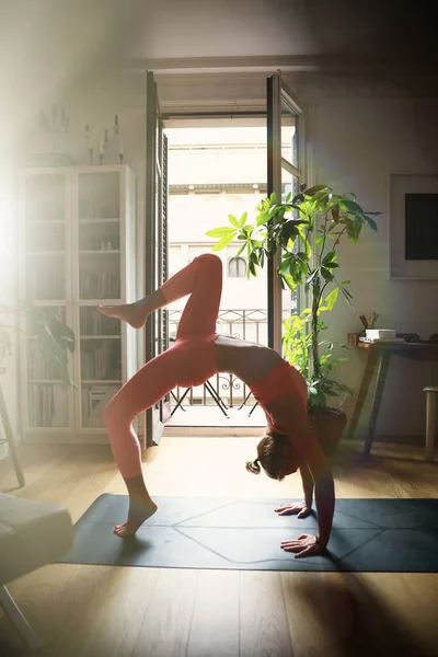 Ritratto verticale di giovane donna che fa yoga in casa, utilizzando il computer portatile cor yoga online. — Foto Stock