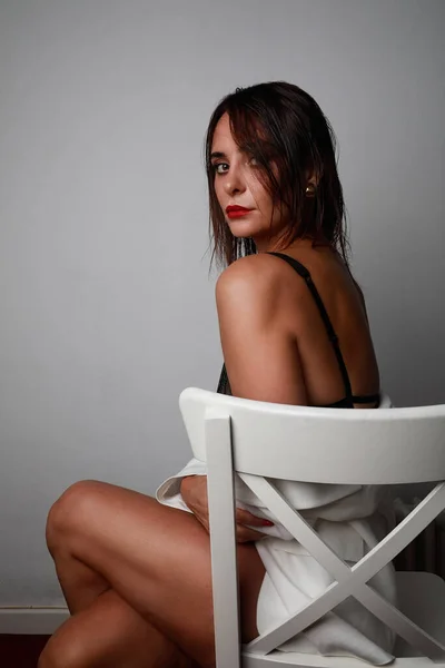 Retrato vertical de una joven atractiva con labios rojos y sentada en la silla. Espacio para texto. —  Fotos de Stock