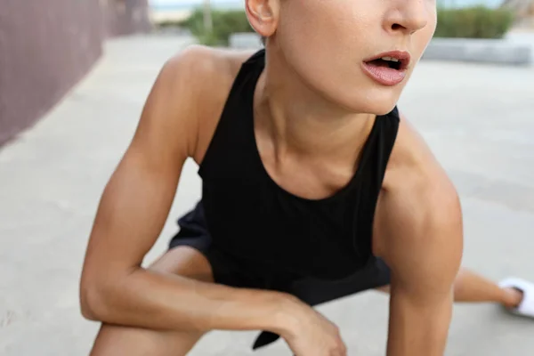 Close-up of athletic woman warming up before a workout doing stretching exercises, close up with copy space. — Stock Photo, Image