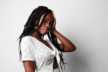 Güzel Afro-Amerikan kadın kafasına dokunuyor ve beyaz arka plan üzerinde poz veriyor, yaşam tarzı insan kavramı..