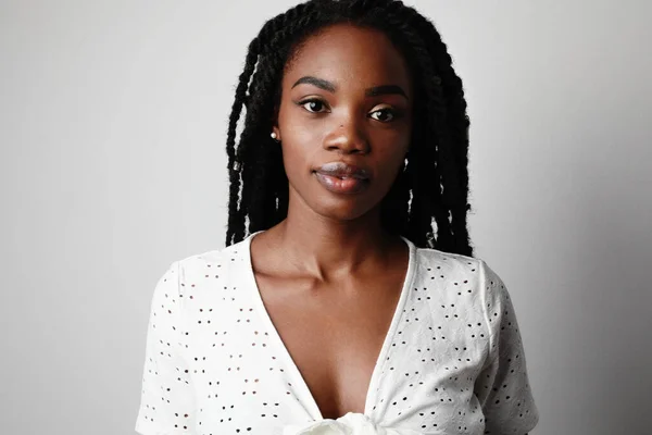 Csinos fiatal afro-amerikai nő pózol vidám fehér háttér, életmód emberek koncepció. A szöveg helye. — Stock Fotó