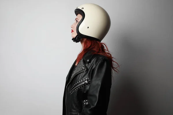 Visão lateral retrato de uma jovem com um capacete de motocicleta posando sobre fundo branco isolado celebrando uma vitória. — Fotografia de Stock